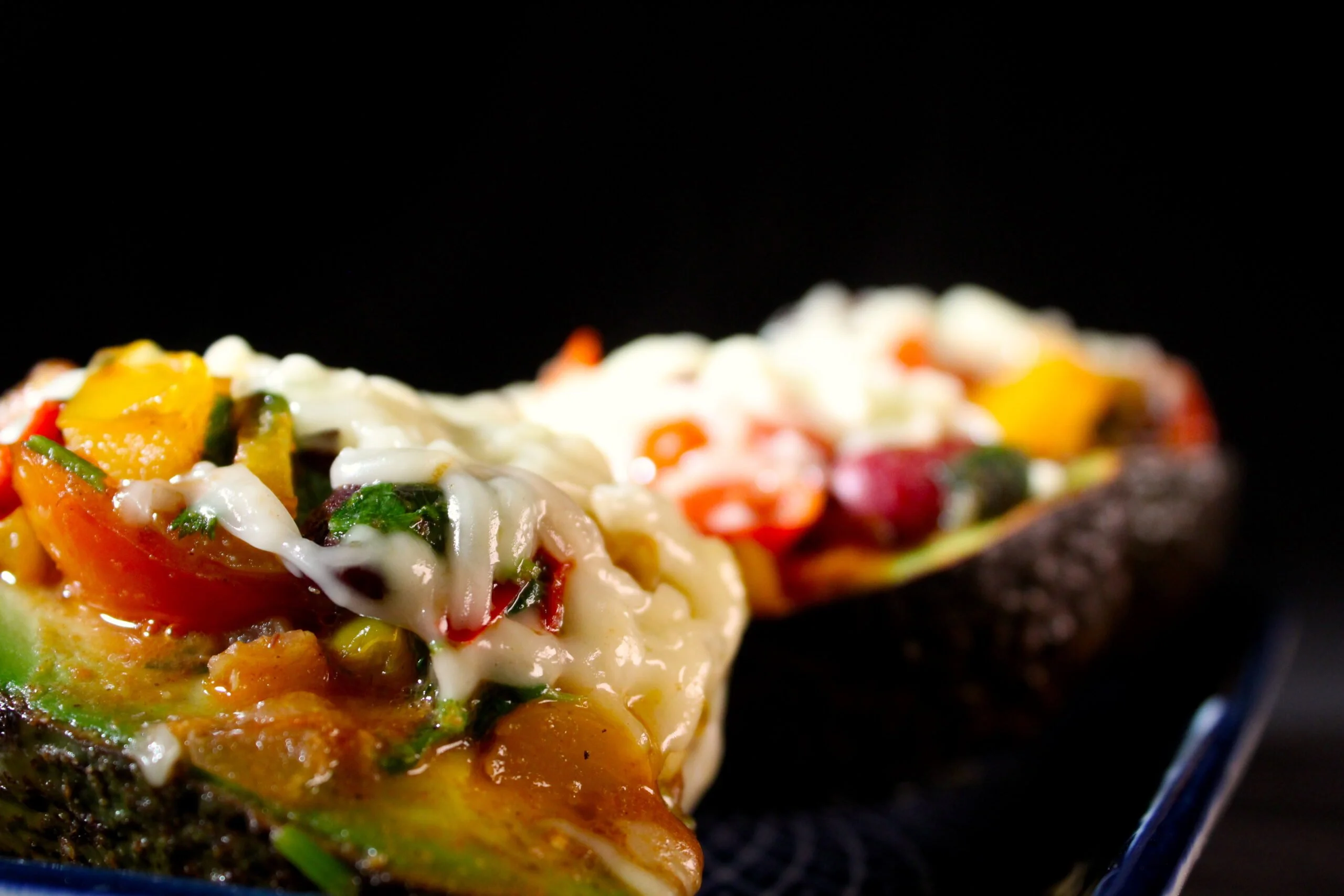 Baked avocado with kidney beans, paprika and tomato