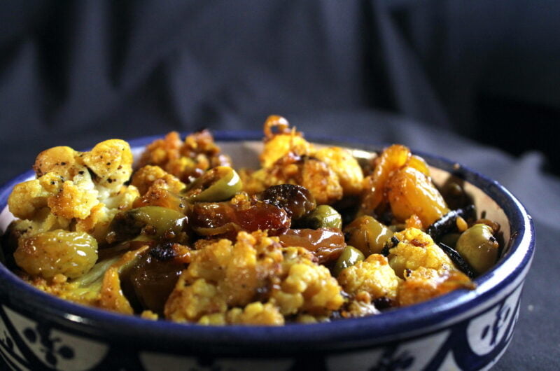 Cauliflower from the oven with green olives and large yellow raisins