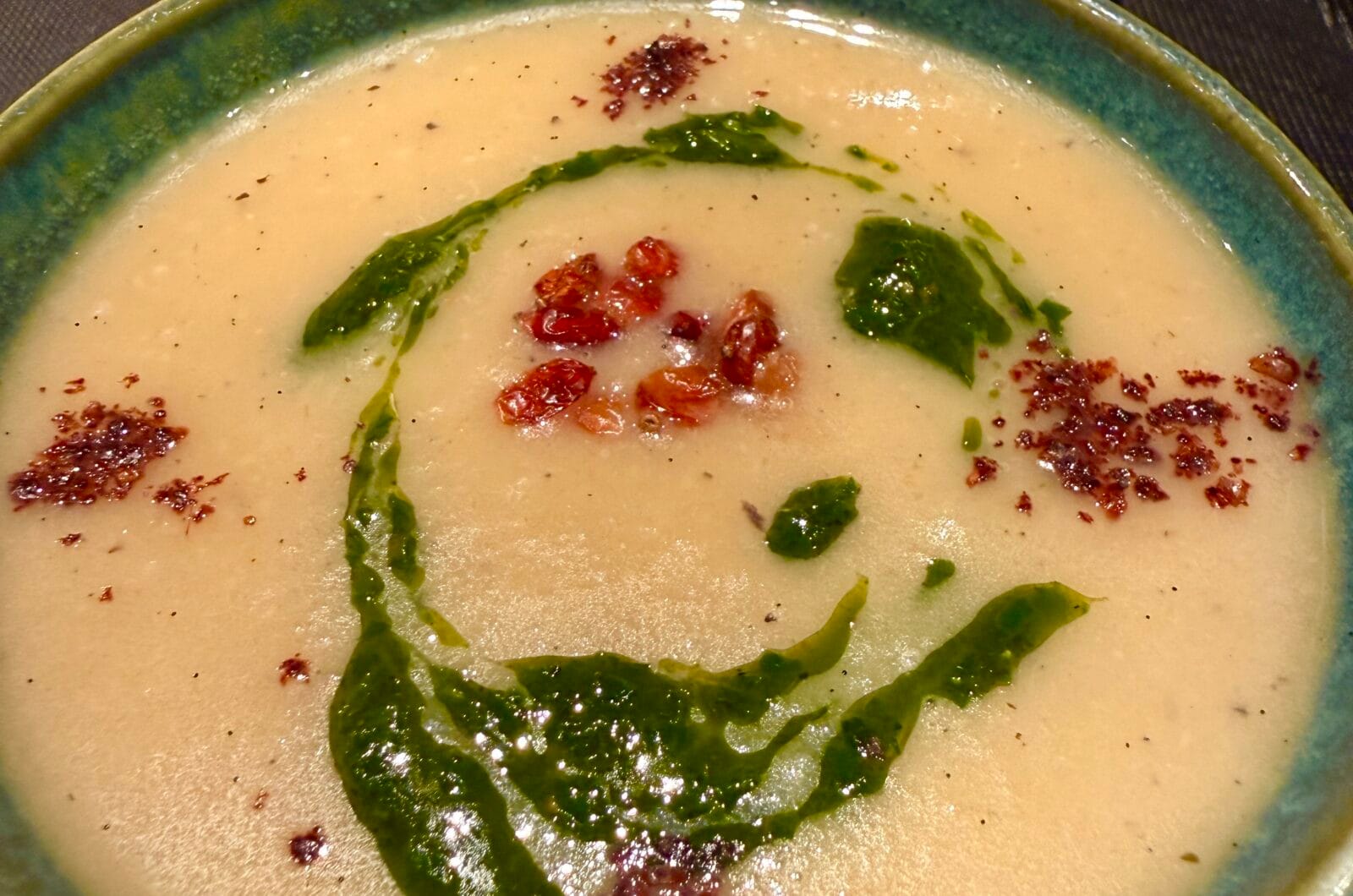 Knolselderijsoep met een vleug vanille, ruccolaolie, zuurbessen en sumak